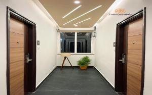 um corredor de escritório com duas portas e um vaso de plantas em Easternwoods Hotels em Bangalore