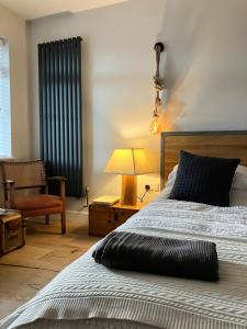 a bedroom with a bed and a lamp and a chair at Fig Tree House in Lymington