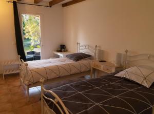 2 camas en una habitación con ventana en La Halte Gourmande, en Vachères