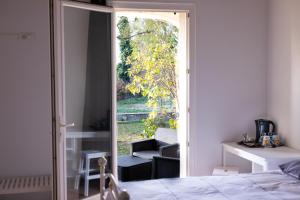 a bedroom with a door open to a patio at La Halte Gourmande in Vachères