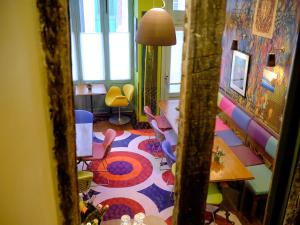 a room with colorful chairs and a table and a mirror at Hotel du Petit Moulin in Paris