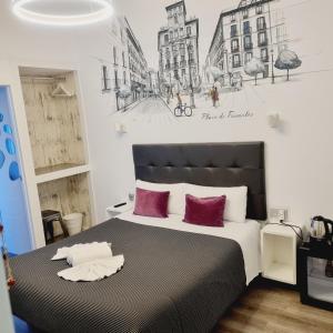 1 dormitorio con 1 cama grande con almohadas rojas en Hostal Lauria, en Madrid