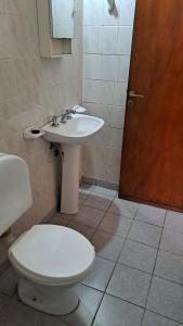 Un baño con un inodoro blanco y un lavabo. en DTOS Villa del Lago, en Villa Carlos Paz