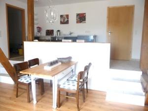 cocina y comedor con mesa y sillas en Ferienhof Sandmann en Wangels