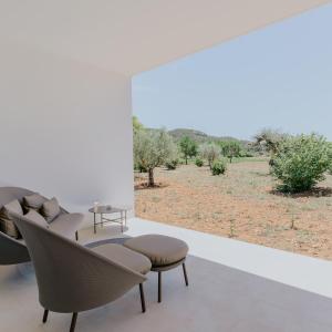 a room with chairs and a view of a field at Ca Na Xica - Hotel & Spa in Sant Miquel de Balansat