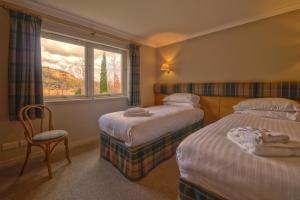 una camera d'albergo con due letti e una finestra di Glen Nevis Holidays a Fort William
