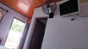Habitación con ventilador y TV en la pared. en Portal de las Viñas en Cafayate