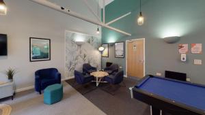 een kamer met een pooltafel en blauwe stoelen bij Comfy Ensuite Bedrooms at Manchester Gardens near City Centre in Manchester