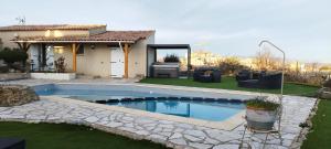 a swimming pool in front of a house at La Halte Gourmande in Vachères