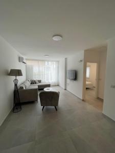 a large living room with a couch and a tv at Apartment Bliss in Bat Yam
