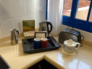 a counter top with cups and a toaster on a counter at Villa Maria Luisa in Playa Blanca