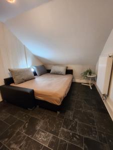 Bett in einem Zimmer mit großem Fliesenboden in der Unterkunft Gästezimmer Sakowski in Lörrach