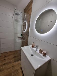 ein weißes Badezimmer mit einem Waschbecken und einem Spiegel in der Unterkunft Nivalis Hill 5, Jahorina in Jahorina