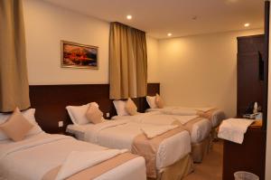 a group of four beds in a hotel room at فندق قرطبة العزيزية in Makkah