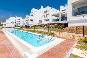 a swimming pool in front of a building at Bahia de Torrequebrada - 2 Bedroom Apartment with Seaview in Benalmádena