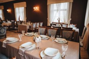 una sala da pranzo con tavolo, piatti e bicchieri di Dworek Komorno a Komorno