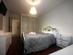 a bedroom with a bed and a dresser at Brisa apart t2 in Ovar