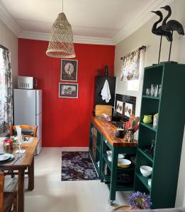 eine Küche mit einem Tisch und einer roten Wand in der Unterkunft Motubane Guest Farm in Madeteleli
