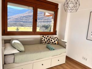 asiento junto a la ventana en una habitación con vistas a la montaña en Fantástico apartamento con vistas en Esterri, en Esterri d'Àneu