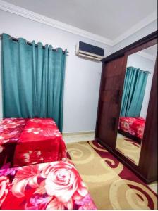 - une chambre avec un lit rouge et un miroir dans l'établissement Dreams House in Maadi, au Caire
