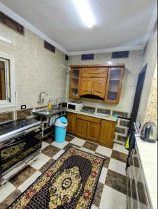 cocina con armarios de madera y suelo de baldosa en Dreams House in Maadi en El Cairo