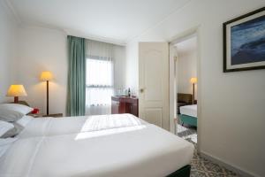 a hotel room with a white bed and a window at Jerusalem Gold Hotel in Jerusalem
