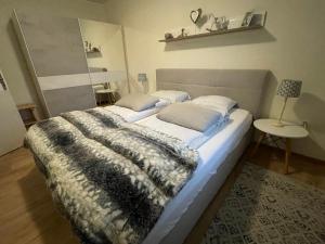 una camera da letto con un letto con una coperta e un tavolo di Apartment Amy a Podcetrtek