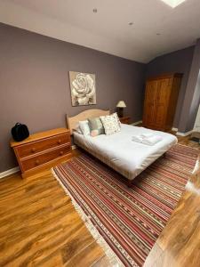 1 dormitorio con 1 cama grande y 1 alfombra en Cosy & Bright Semi-Detached House en Edimburgo
