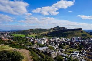 an aerial view of a city with mountains in the background at Cosy & Bright Semi-Detached House in Edinburgh