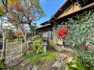 a house with a fence and some plants at Kyoto Wakouan Retro Stay in Kinugasa