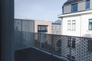 einen Balkon mit einem Metallzaun und einigen Gebäuden in der Unterkunft Triangle City Apartment II in Wien