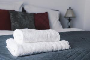 una pila de toallas sentadas encima de una cama en Triangle City Apartment II, en Viena