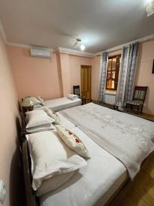 1 dormitorio con 2 camas y ventana en Hotel Al Mansur, en Bukhara