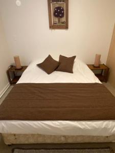 a bedroom with a bed with two nightstands and a clock at Departamentos Caldera Suites in Caldera