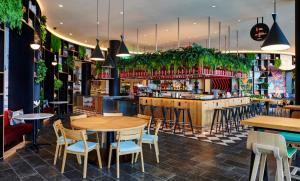 a restaurant with tables and chairs and a bar at citizenM Miami Worldcenter in Miami
