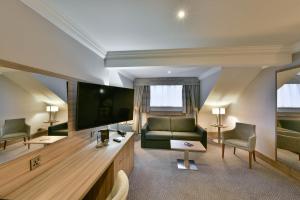 a living room with a couch and a television at Holiday Inn - Manchester - Oldham, an IHG Hotel in Manchester