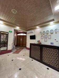 a lobby with a wall with plates on it at Hotel Al Mansur in Bukhara