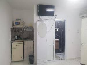 a kitchen with a tv on top of a refrigerator at Nitra rooms in Neve Zohar