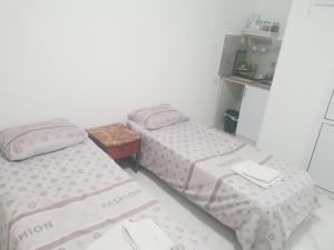 two twin beds in a room with a table at Nitra rooms in Neve Zohar