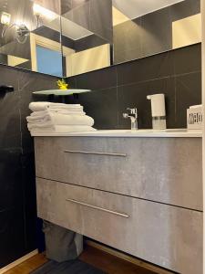 uma casa de banho com um lavatório e um balcão com toalhas em San Siro Terrace Attic Apartment Milano em Milão