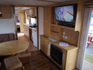 a small living room with a tv and a table at Baza Turystyczna Atol in Władysławowo