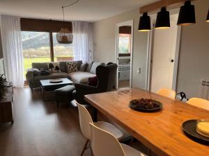 sala de estar con mesa y sofá en Fantástico apartamento con vistas en Esterri, en Esterri d'Àneu