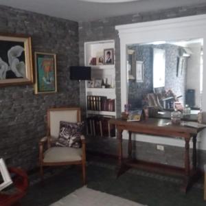 ein Wohnzimmer mit einem Schreibtisch und einem Stuhl in der Unterkunft Los Aceres in Salta