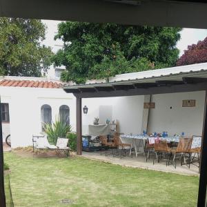een patio met een tafel en stoelen in een tuin bij Los Aceres in Salta