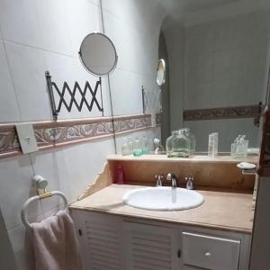 W łazience znajduje się umywalka i lustro. w obiekcie Los Aceres w mieście Salta
