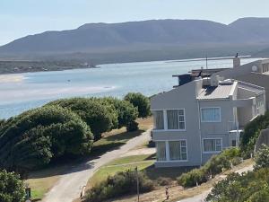 a house on a hill next to a body of water at Breede View Holiday Home in Witsand