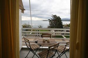 a balcony with a table and chairs and a view of the water at Lovely sea front apartment in Itea
