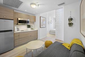 eine Küche und ein Wohnzimmer mit einem Sofa und einem Tisch in der Unterkunft Barbizon on Ocean Drive Apartments in Miami Beach