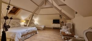 Schlafzimmer mit einem Bett, einem TV und einem Stuhl in der Unterkunft Un Parfum de Campagne in Méaulte