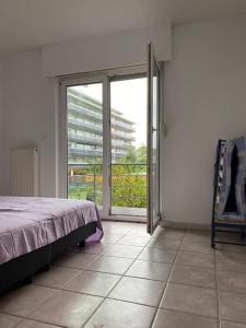 um quarto com uma cama e uma grande porta de vidro deslizante em Superbe appartement lumineux et spacieux em Antuérpia